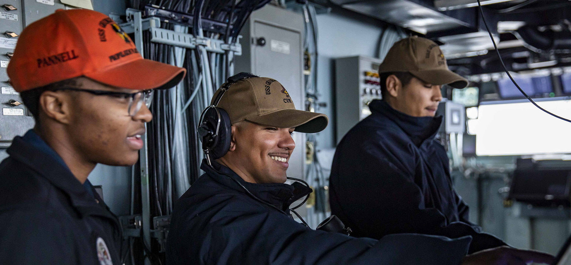 Three men from a different service division train together on a ship